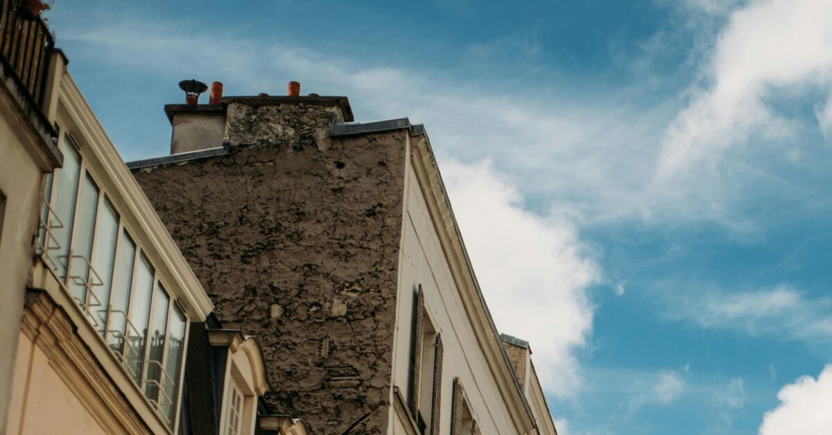 Experience an enchanting Paris street with classic architecture and birds in flight under a blue sky.